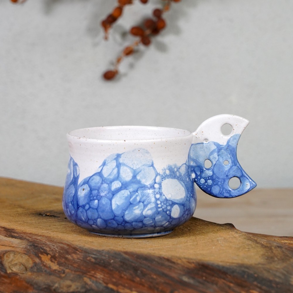 blue and white bubbles mug with blue textured lower surface and sculpted handle