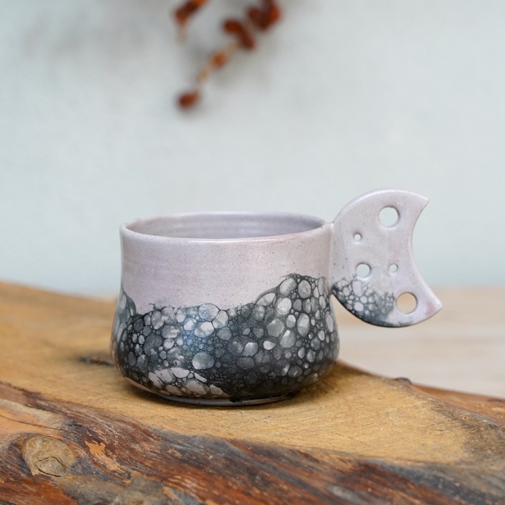 grey and black ceramic mug with bubble texture detail and decorative handle