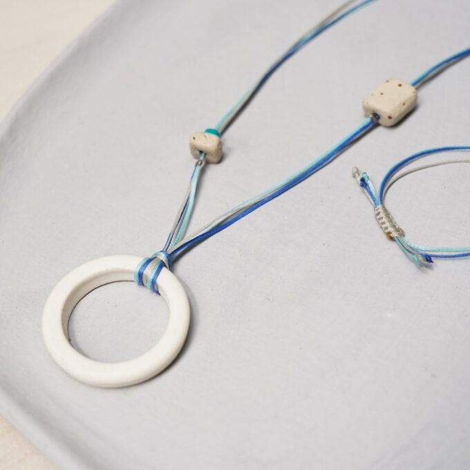 matte white ceramic ring necklace with layered blue waxthread