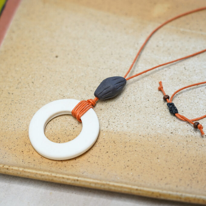 off-white ceramic ring necklace with burnt orange waxthread