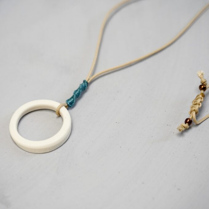 off-white ceramic ring necklace with teal thread wrap and waxthread