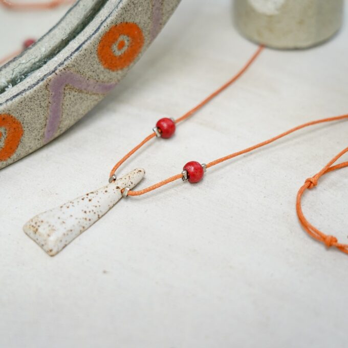 orange waxthread necklace with speckled ivory tapered ceramic element