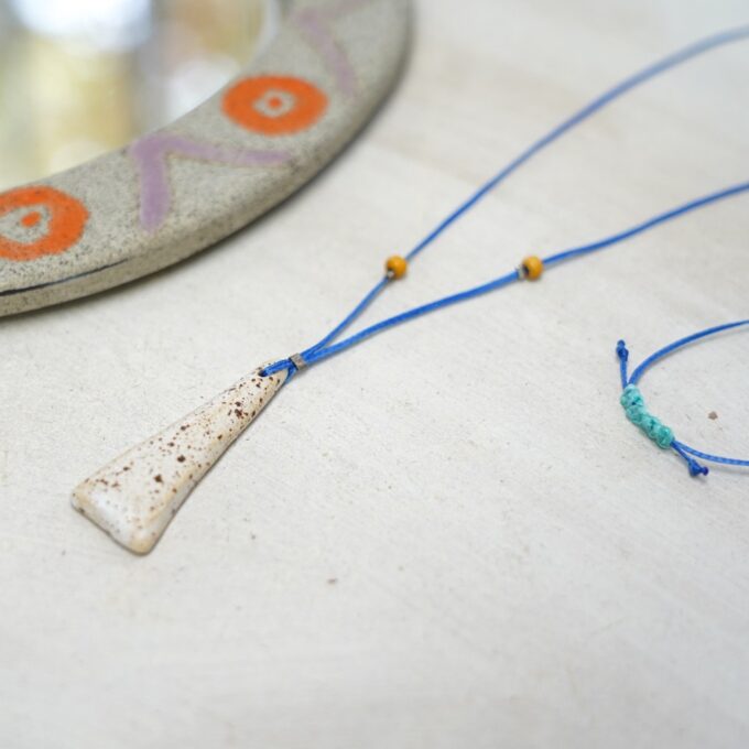 blue waxthread necklace with ivory tapered ceramic pendant and yellow beads