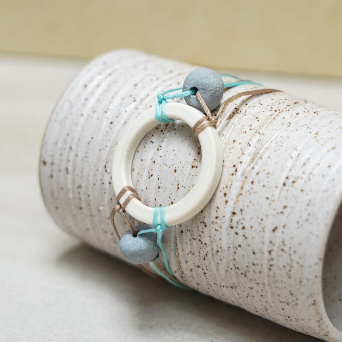 unique waxthread bracelet with handmade white porcelain circle and subtle color accents