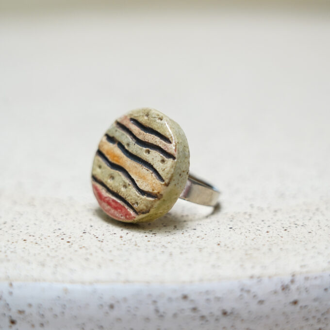 striped round ceramic ring with earthy tones on a minimal band