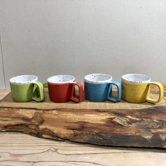 espresso cups in different colors on wooden surface