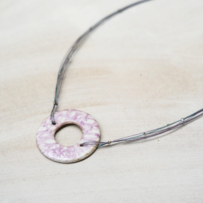 lilac patterned ceramic wire necklace on light surface