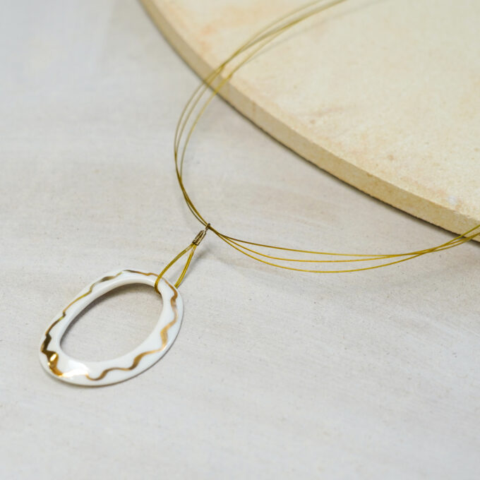 white ceramic oval ring wire necklace with gold detailing