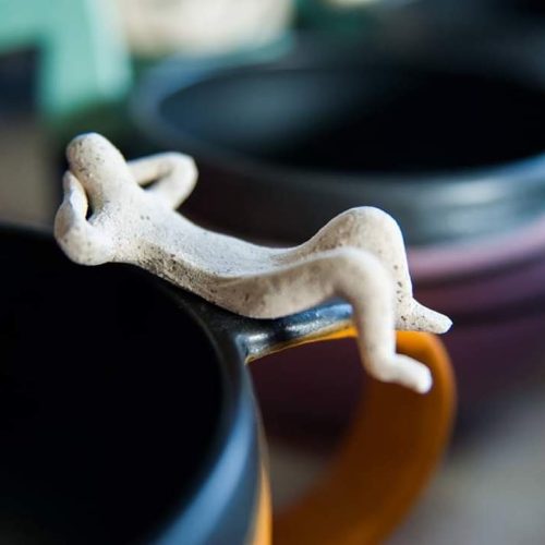 Close-up of handmade ceramic mug with sculpted human figure detail – Greek pottery by Stella Nedoglou